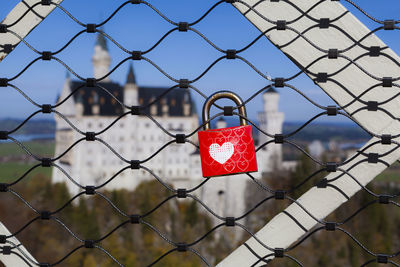 Close-up of padlocks hanging on chainlink fence