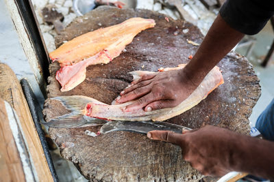 Cropped hand of person preparing food at market stall