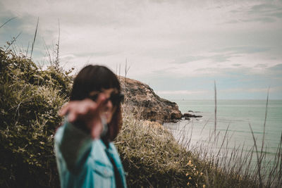 Smiling woman gesturing while standing by plants