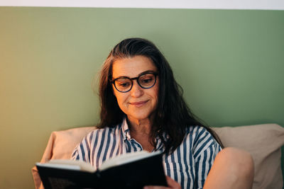 Portrait of smiling woman sitting on sofa at home