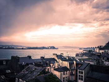 High angle view of townscape by sea against sky during sunset