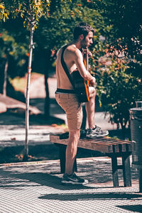 Full length of young man standing on bench