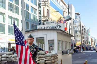 Man standing on street amidst buildings in city