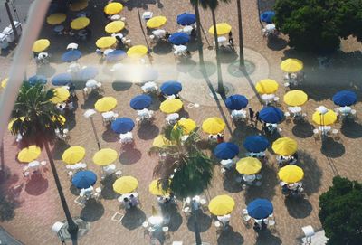 High angle view of parasols at outdoor restaurant seen from glass window