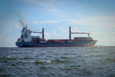 Ship sailing on sea against sky