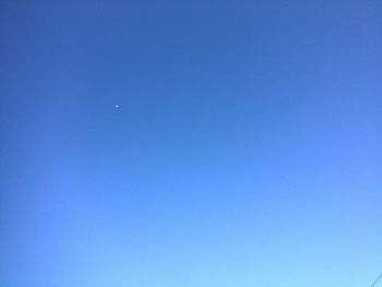 Low angle view of moon in blue sky