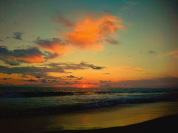 Scenic view of sea against dramatic sky during sunset