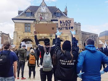 Rear view of people against buildings in city