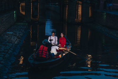 People sitting on boat in canal