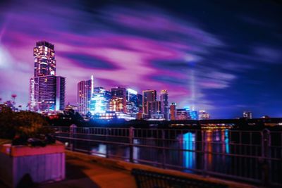 Illuminated buildings in city against sky at night