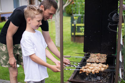 Young man preparing food on barbecue grill