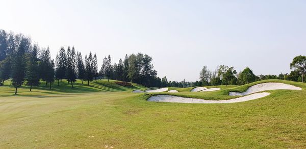 Panoramic view of golf course against clear sky