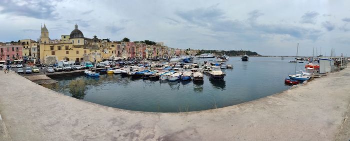 Boats moored in harbor by buildings in city