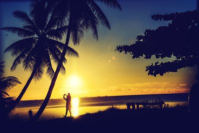 Silhouette people at beach during sunset