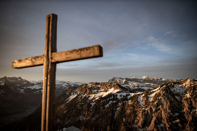 Panoramic view of cross on mountain against sky during winter