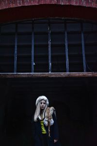 Low angle view of young woman standing against ceiling