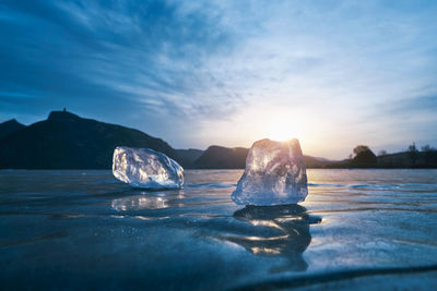 Scenic view of frozen lake against sky during sunset