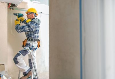 Man drilling in wall at home