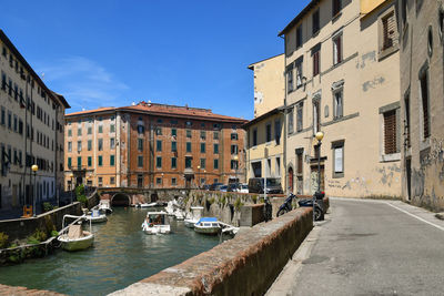 Canal amidst buildings in city against sky