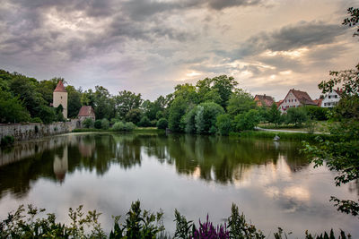 Scenic view of lake by buildings against sky