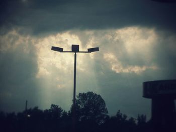 Low angle view of street light against cloudy sky