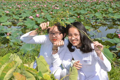 Low angle view of young woman standing by plants
