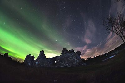 Old ruins against aurora polaris at night