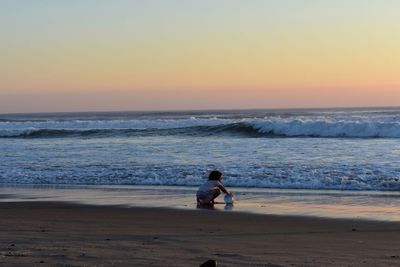 Silhouette woman walking at beach during sunset