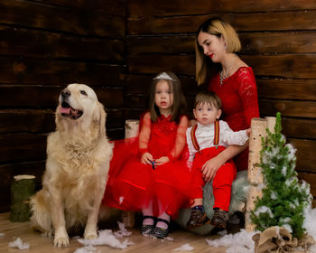 Portrait of young woman with dog sitting on sofa at home