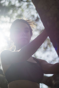 Low angle view of woman sitting in sunlight