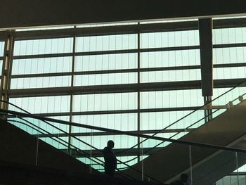 Low angle view of silhouette man standing in modern building