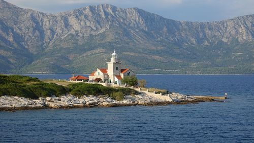 Scenic view of sea and buildings against mountains