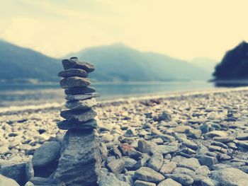 Stack of pebbles on beach against sky