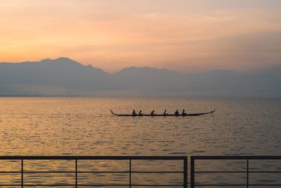 Silhouette boats in sea against sky during sunset