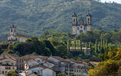 View of townscape by trees and houses against mountain