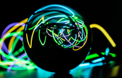 Close-up of illuminated light bulb against black background