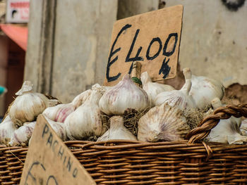 Close-up of garlic bulbs in basket for sale at market