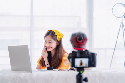 Portrait of smiling young woman using mobile phone