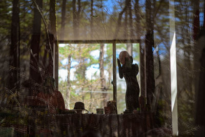 Woman standing by trees in forest