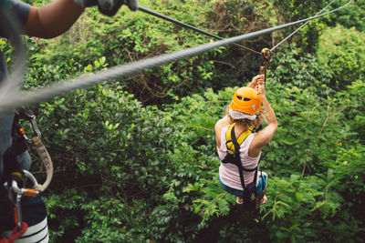 High angle view of woman ziplining in forest
