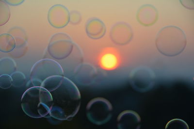 Bubbles in mid-air against orange sun