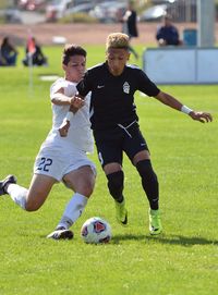 Men playing soccer on field