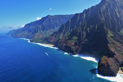 Scenic view of sea and mountains against blue sky