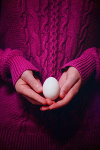Midsection of woman holding egg