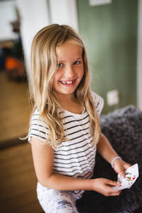 Girl with playing cards looking at camera