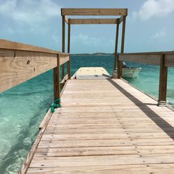 Wooden pier on beach against sky