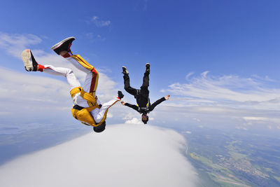 Low angle view of man jumping against sky