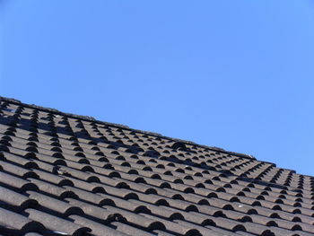 Low angle view of roof and building against clear blue sky