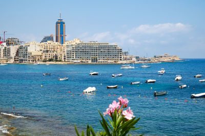 Scenic view of sea by buildings against sky