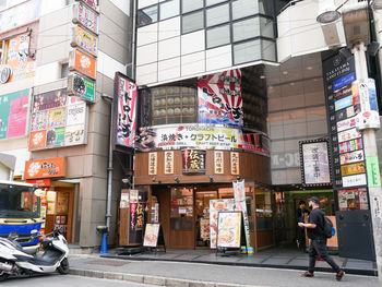 Man walking on city street by buildings